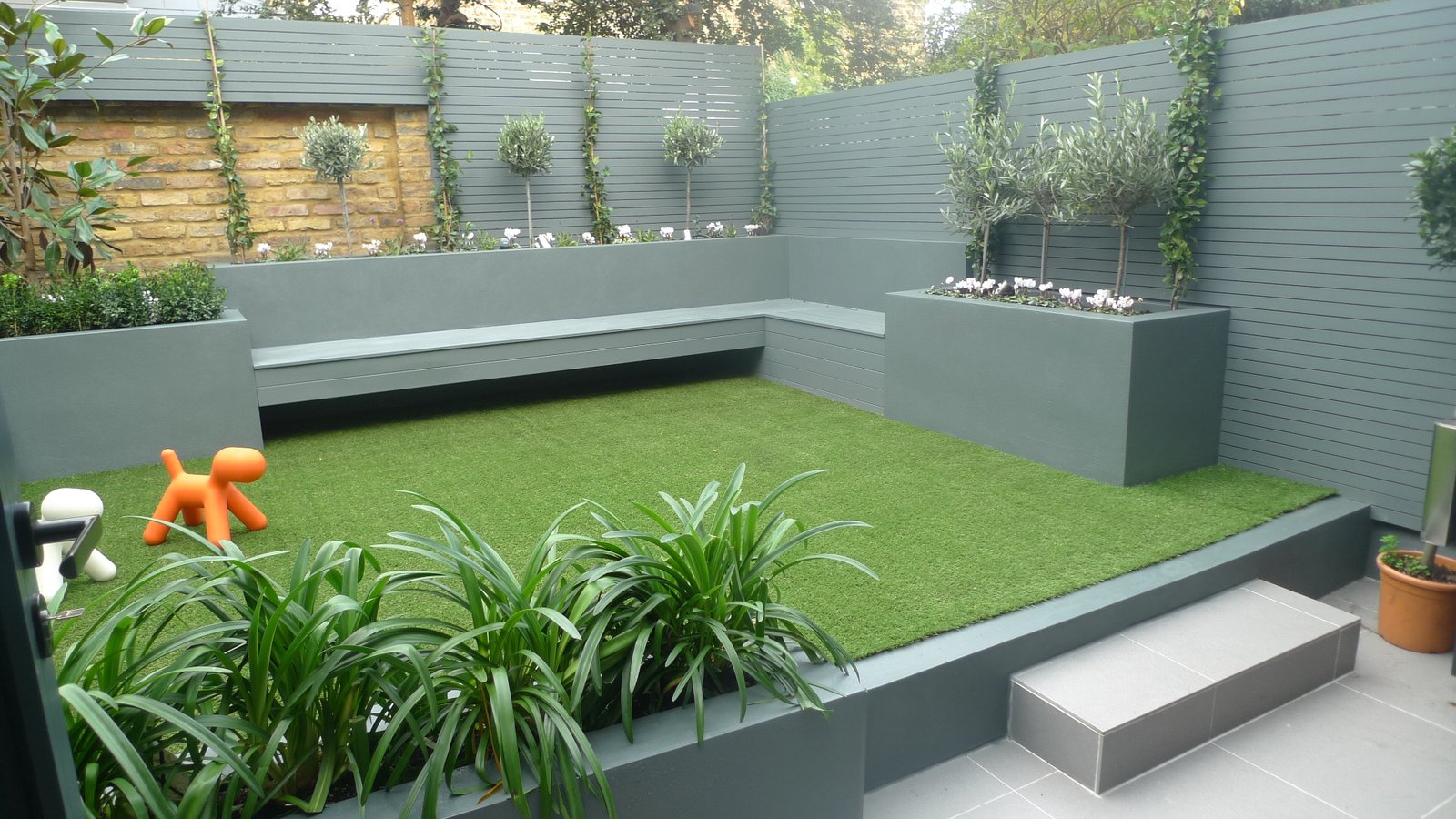 Modern small low maintenance garden fake grass grey raised ...